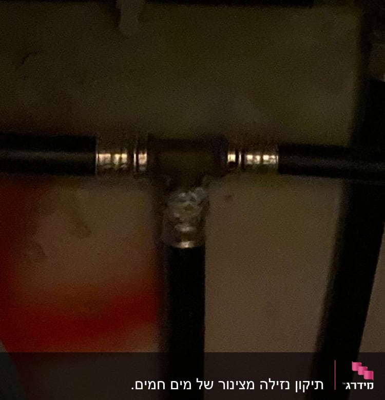 צינורות שחורים עם מחברים מתכתיים בקיר